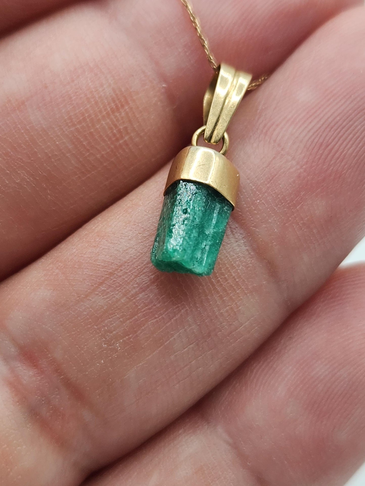 Pendiente de Esmeralda Natural sin Pulir, extraída de las minas de Muzo en Colombia, engastada en Oro de 18k, trabajo hecho a mano totalment