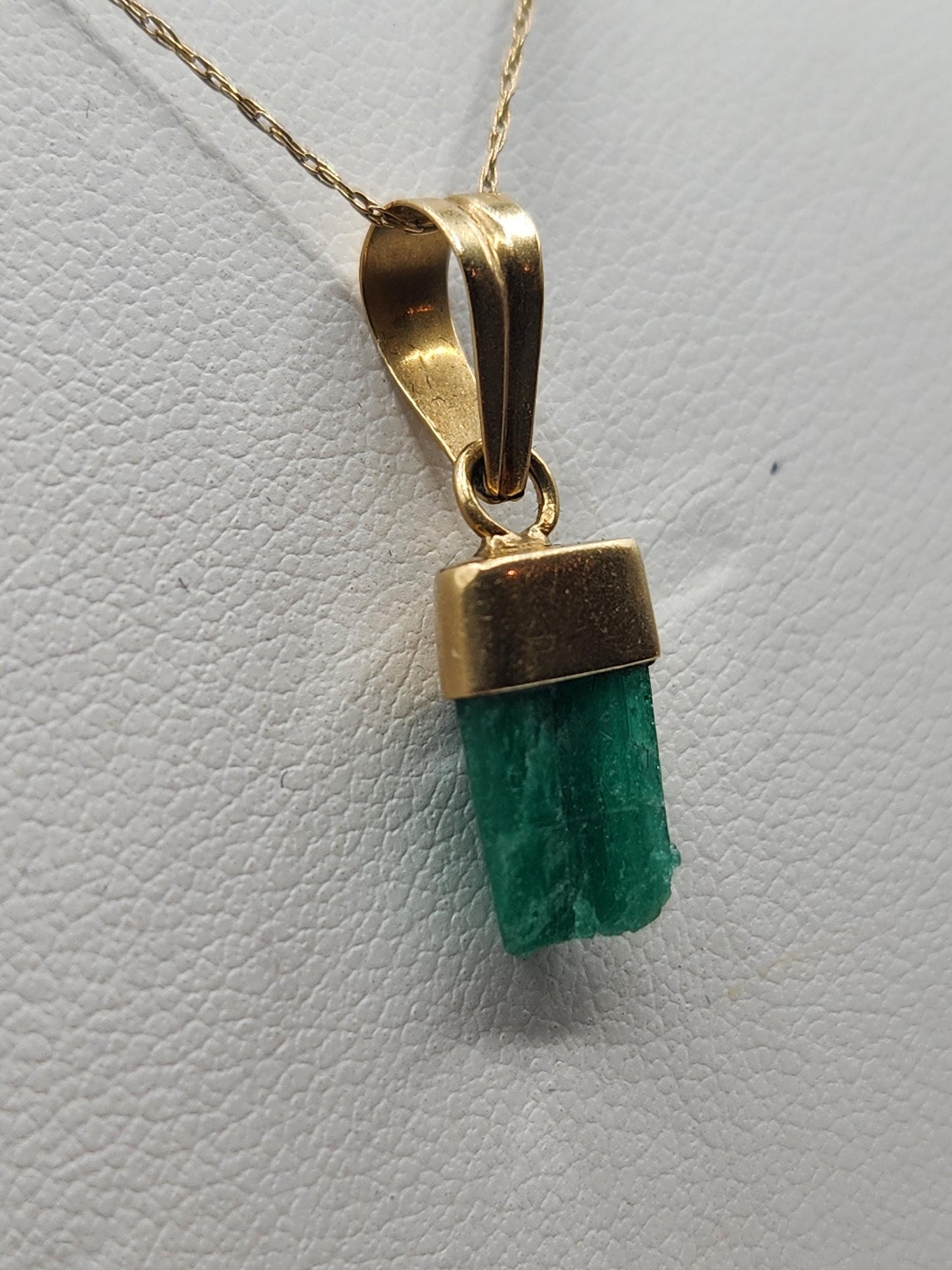 Pendiente de Esmeralda Natural sin Pulir, extraída de las minas de Muzo en Colombia, engastada en Oro de 18k, trabajo hecho a mano totalment