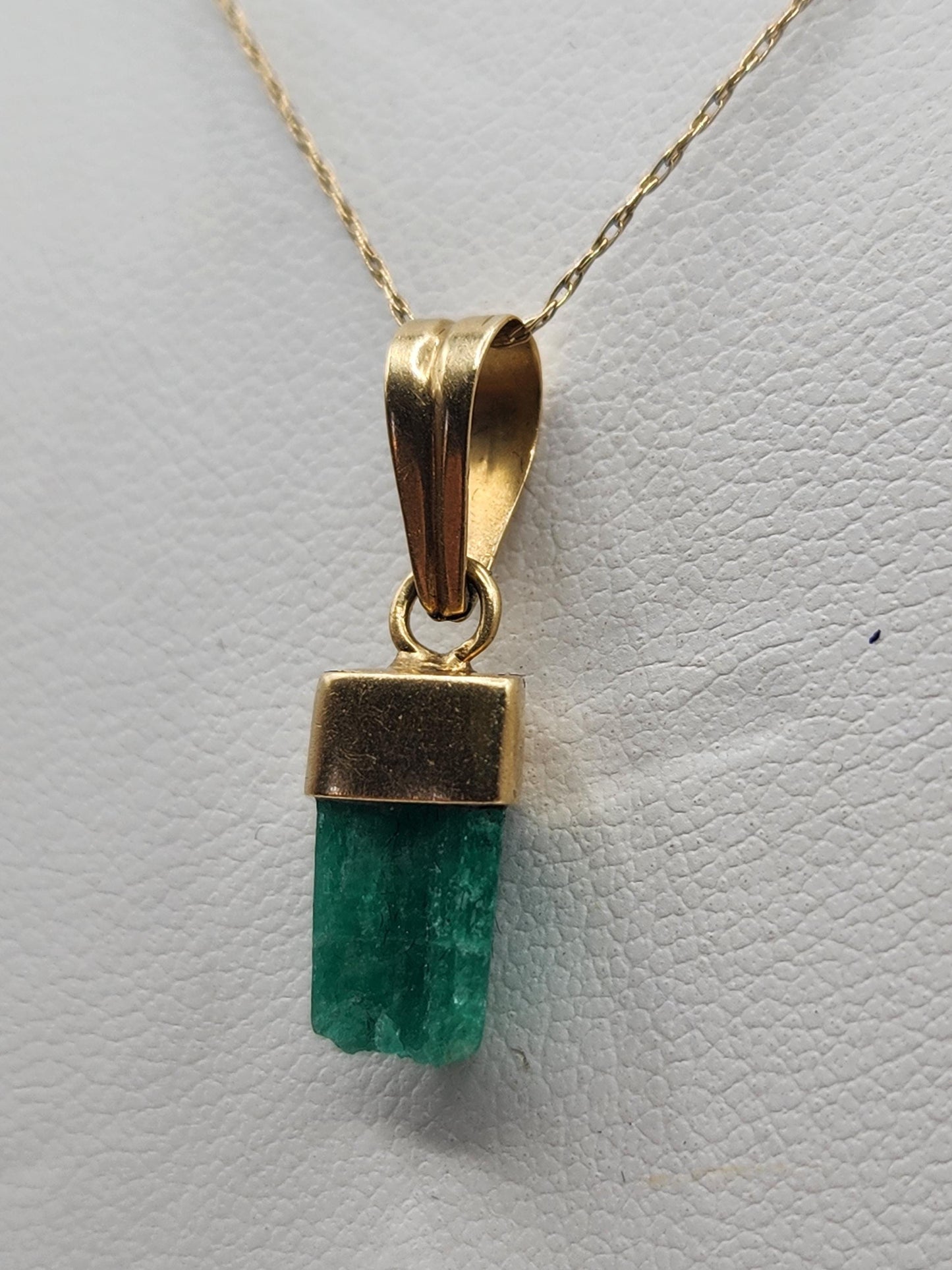 Pendiente de Esmeralda Natural sin Pulir, extraída de las minas de Muzo en Colombia, engastada en Oro de 18k, trabajo hecho a mano totalment