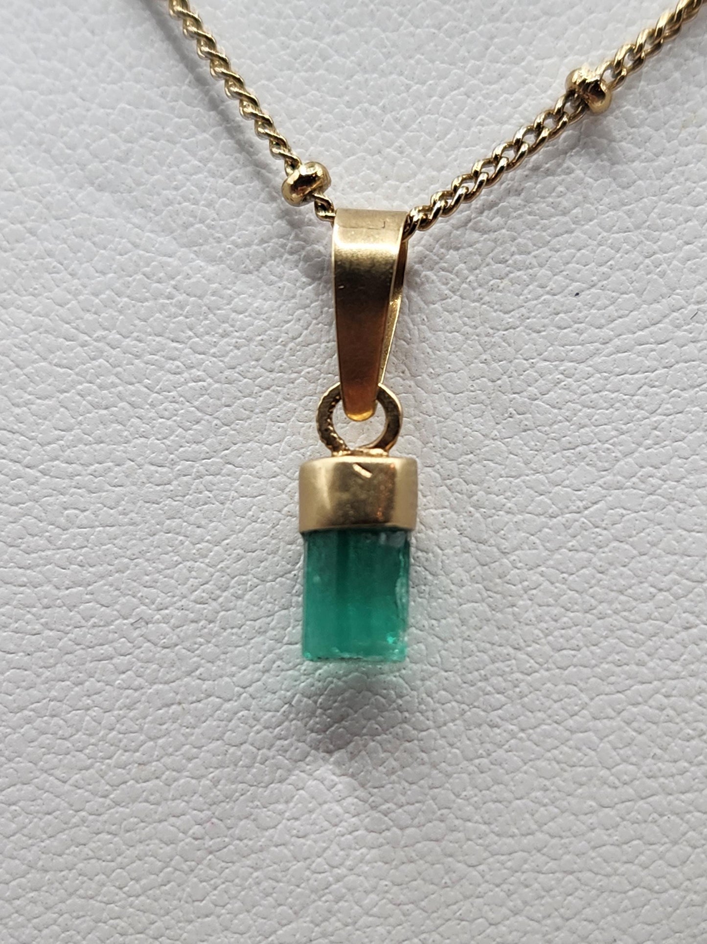Pendiente de Esmeralda Natural sin Pulir, extraída de las minas de Muzo en Colombia, engastada en Oro de 18k, trabajo hecho a mano totalment