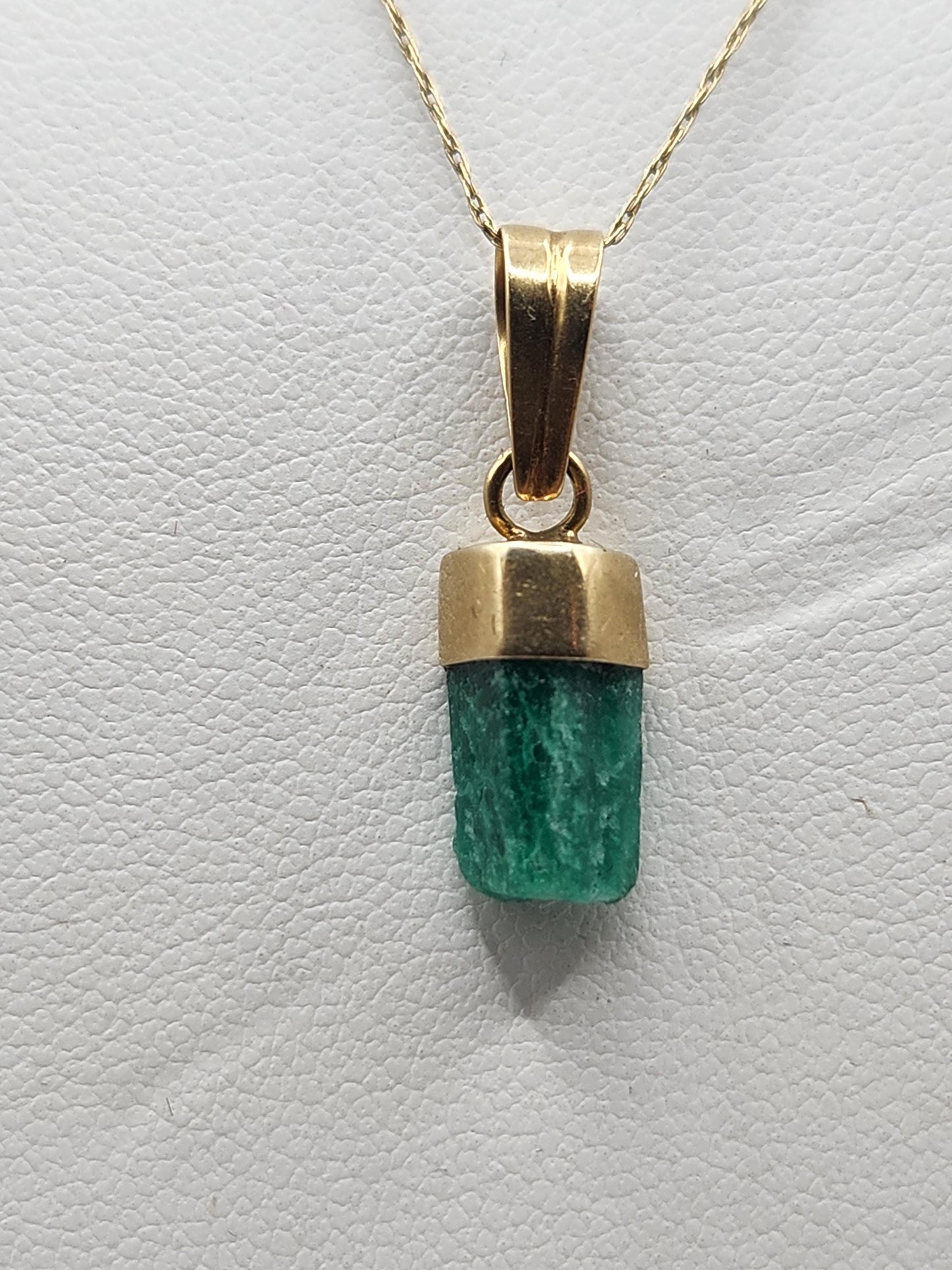 Pendiente de Esmeralda Natural sin Pulir, extraída de las minas de Muzo en Colombia, engastada en Oro de 18k, trabajo hecho a mano totalment