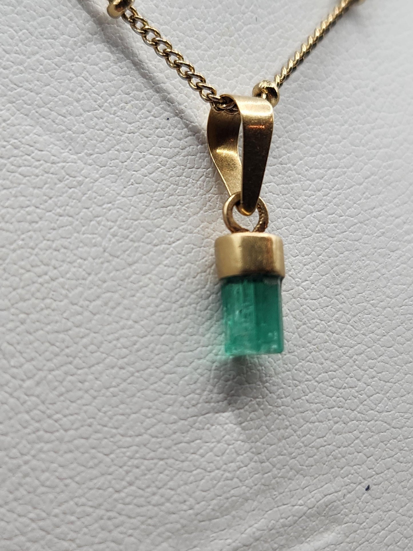 Pendiente de Esmeralda Natural sin Pulir, extraída de las minas de Muzo en Colombia, engastada en Oro de 18k, trabajo hecho a mano totalment