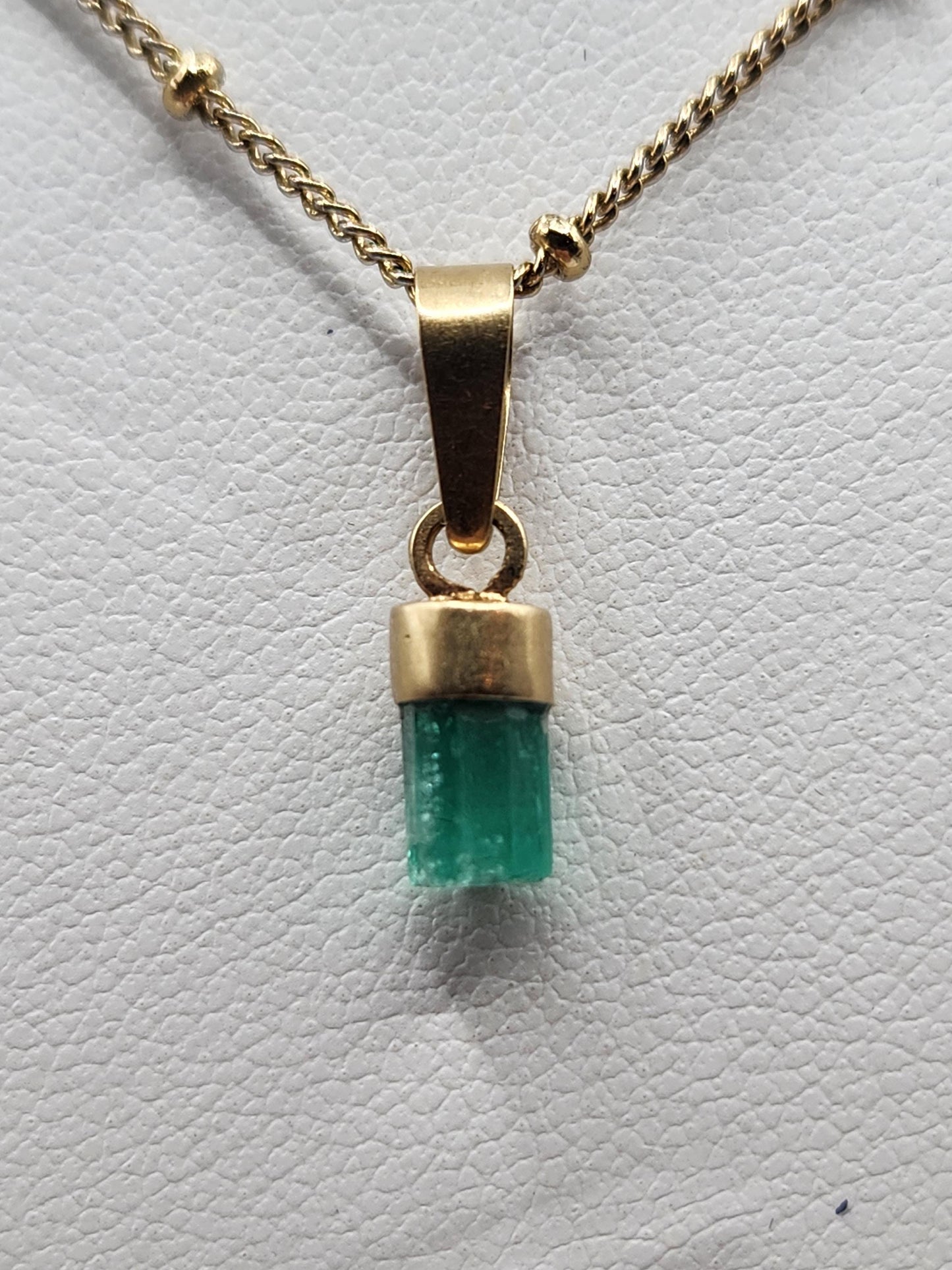 Pendiente de Esmeralda Natural sin Pulir, extraída de las minas de Muzo en Colombia, engastada en Oro de 18k, trabajo hecho a mano totalment