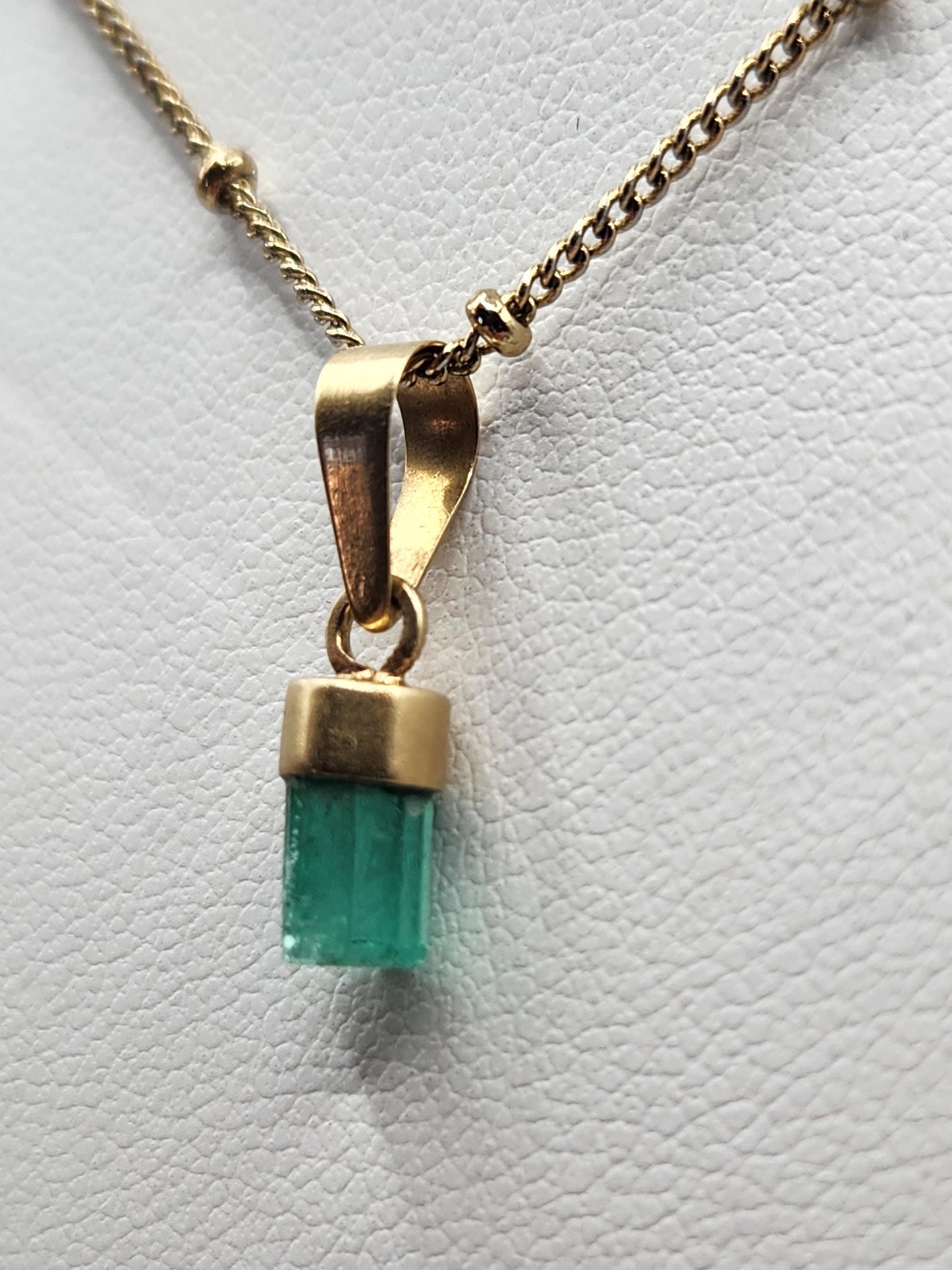 Pendiente de Esmeralda Natural sin Pulir, extraída de las minas de Muzo en Colombia, engastada en Oro de 18k, trabajo hecho a mano totalment