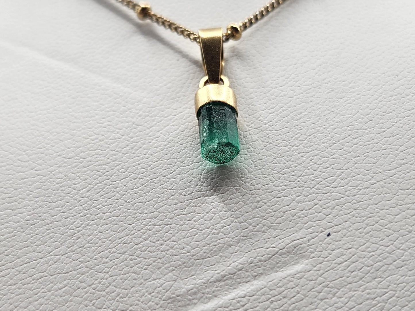 Pendiente de Esmeralda Natural sin Pulir, extraída de las minas de Muzo en Colombia, engastada en Oro de 18k, trabajo hecho a mano totalment