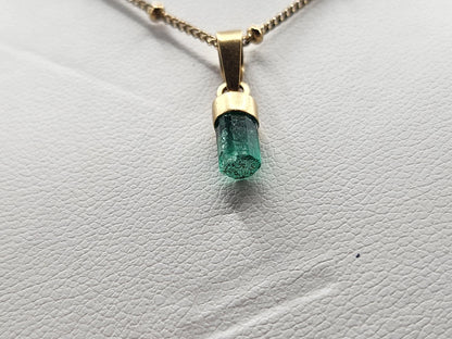 Pendiente de Esmeralda Natural sin Pulir, extraída de las minas de Muzo en Colombia, engastada en Oro de 18k, trabajo hecho a mano totalment