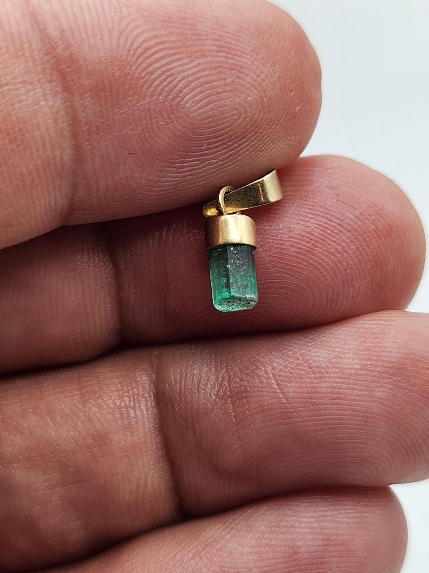 Pendiente de Esmeralda Natural sin Pulir, extraída de las minas de Muzo en Colombia, engastada en Oro de 18k, trabajo hecho a mano totalment